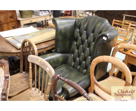 A green leather upholstered button back wing back armchair 
