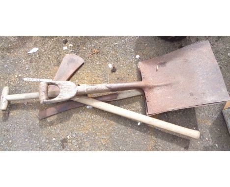 A small assortment of garden tools comprising broad shovels, axe and grass knife
