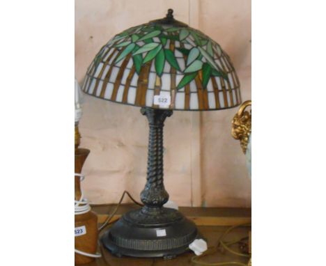 A modern cast metal column form table lamp with decorative Tiffany style shade