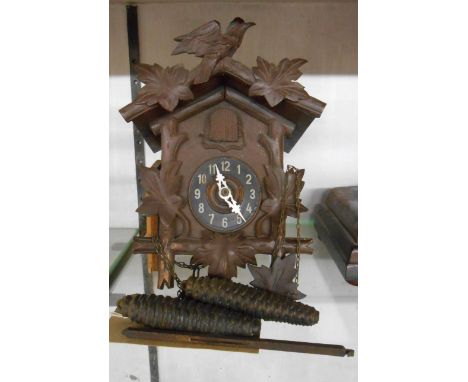 A small vintage stained wood cased cuckoo wall clock with twin pine cone pattern weight driven movement