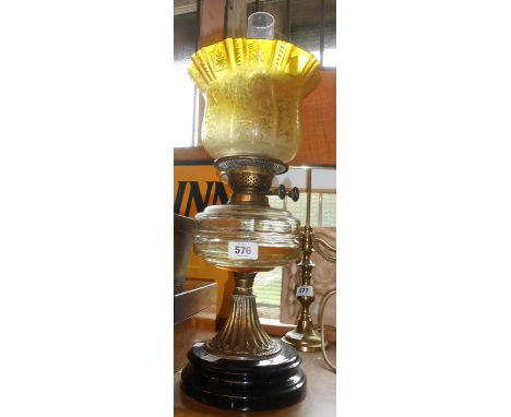 A Victorian burner oil lamp with Hinks twin burner and clear glass faceted reservoir on brass acanthus support with ceramic b