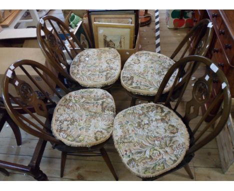 A set of four Ercol dark elm fleur de lys hoop stick back dining chairs with solid moulded seats, set on simple turned suppor