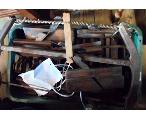 A crate containing assorted antique carpenter's tools including thirty moulding planes, large saw, etc.