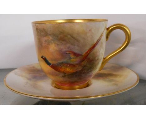 A Royal Worcester demi-tasse coffee cup and saucer handpainted with pheasants amidst a moorland backdrop - signed Jas Stinton