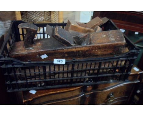 A crate containing an assortment of antique woodworking tools including planes, chisels, etc.