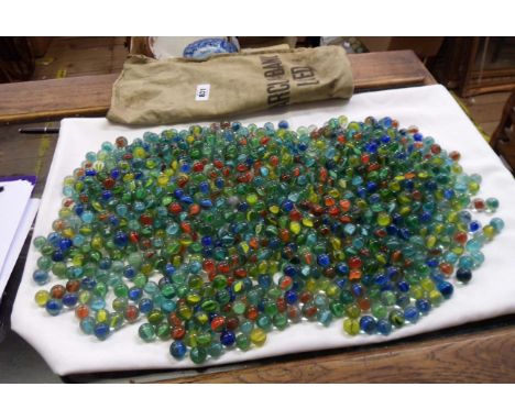 An old Barclays bank money bag containing a large quantity of vintage marbles