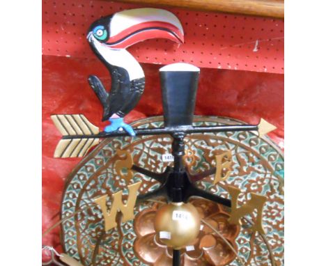 A modern cast metal weather vane with Guinness toucan motif to top