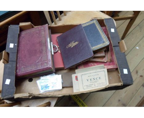 A late Victorian cabinet album containing posed photographic portraits - sold with vintage souvenir photographic postcards, a