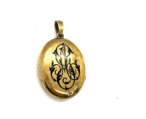 Antique yellow metal and enamel locket containing a lock of hair weight 18grams size 3.5cm by 2.6cm 