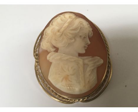 An unmarked gold cameo brooch. A side profile portrait of a young lady.