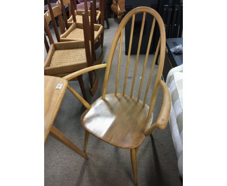 A blonde Ercol elm and beechwood kitchen table of rectangular shape and two matching open arm chairs. Some scratches top with