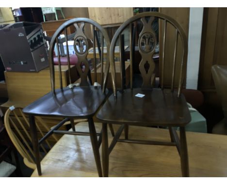 A set of four Ercol cottage style dining chairs with shaped backs and solid seats (4)