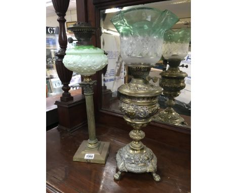 An ornate brass oil lamp plus a brass corintihum column oil lamp with milk glass reservoir.