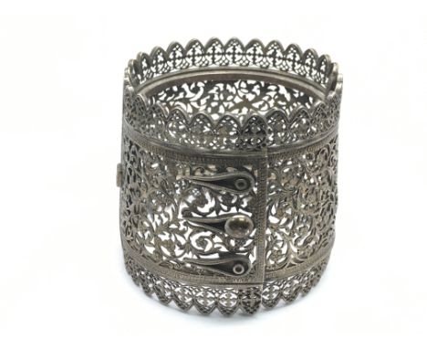 A silver bangle with pierced decoration.