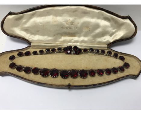 A Christian Dior necklace set with red stones , set in white metal, the clasp stamped CHR Dior 1962 .
