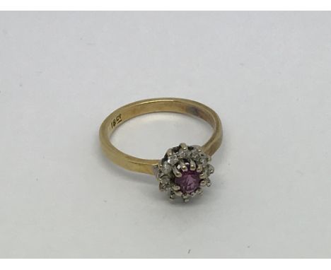 An 18ct gold ring set with a ruby and diamond clusters. Size j approx weight 2.6g