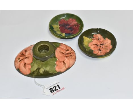 THREE PIECES OF GREEN MOORCROFT POTTERY 'HIBISCUS' ITEMS comprising an oval squat candlestick with a queen Mary sticker to th
