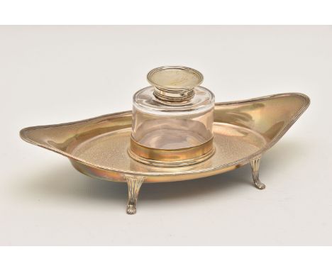 AN EARLY 20TH CENTURY SILVER INK WELL WITH TRAY, the oval tray with slotted space for the glass ink well, raised on four cabr