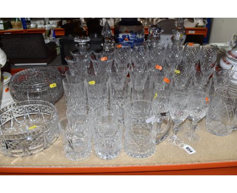 A GROUP OF CUT GLASSWARE, comprising a selection of drinking glasses, large fruit bowls, and decanters with stoppers, tankard