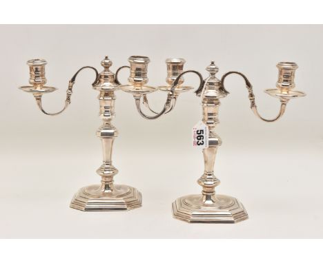A PAIR OF SILVER CANDLEABRAS, each with twin scroll branches, polished drip pans, knopped tapering stems, on square stepped b