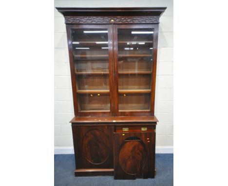 AN EARLY 20TH CENTURY MAHOGANY BOOKCASE, with double glass doors, atop a base with double cupboard doors, that are enclosing 