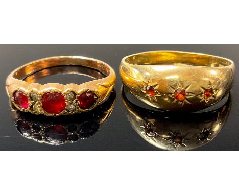 A 9ct gold three stone garnet ring, size R, marked 375, 2g; a gold plated dress ring, set with paste stones, size O (2) 