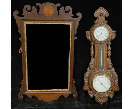 An Edwardian wall hanging combination aneroid barometer, thermometer and timepiece, of maritime interest with carved rope twi