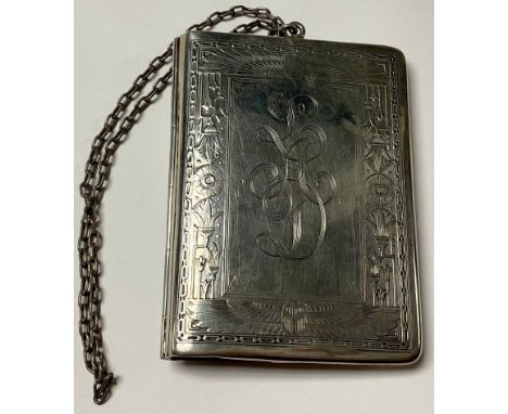 An early 20th century Egyptian revival sterling silver rounded rectangular purse, engine turned with stylised wings and leafy