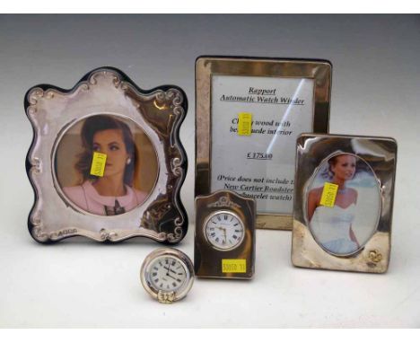 Two small silver mounted quartz clocks and three silver photo frames (5) Condition report: see terms and conditions. This lot