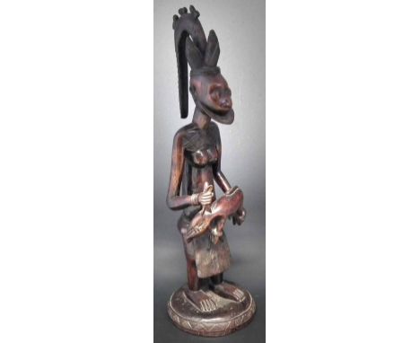 Yoruba figure of a man with a sacrificial animal, 91cm high     All lots in this Tribal and African Art Sale are sold subject