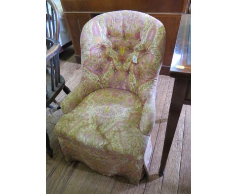 A Victorian button upholstered nursing chair with turned tapering legs and castors
