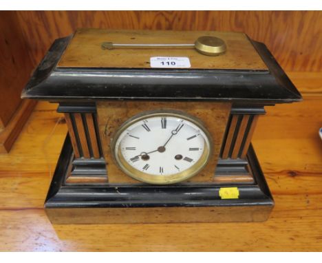 A mid Victorian walnut and ebonised mantel clock of architectural form with fluted sides, the enamel dial with French movemen