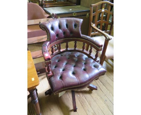 A red leather upholstered swivel office chair, the button upholstery with spindle supports, cross frame and castors 