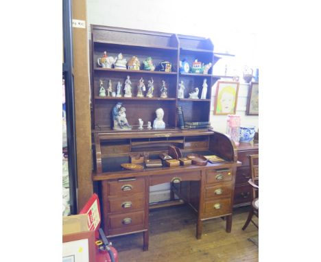 An oak tambour top desk, with shelf superstructure, the roll top enclosing a fitted interior over a central drawer flanked by