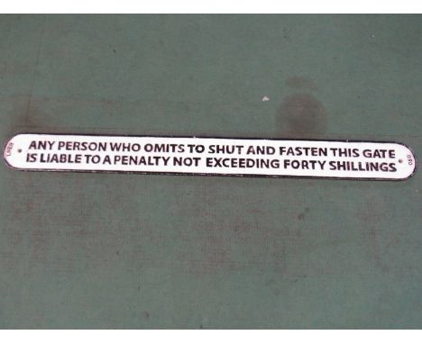 A reproduction LNER cast iron sign: ANY PERSON WHO OMITS TO SHUT AND FASTERN THIS GATE IS LIABLE TO A PENALTY NOT EXCEEDING F