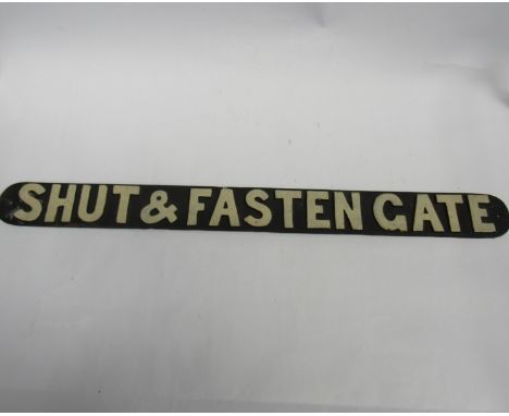 A reproduction cast iron sign - SHUT AND FASTEN GATE, black painted with white letters