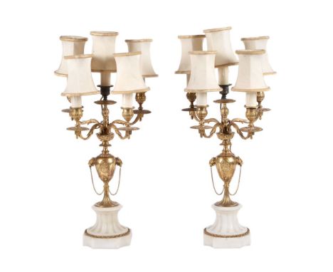 A pair of gilt metal and white marble mounted five light candelabra fitted as table lamps, circa 1900 and later adapted, the 