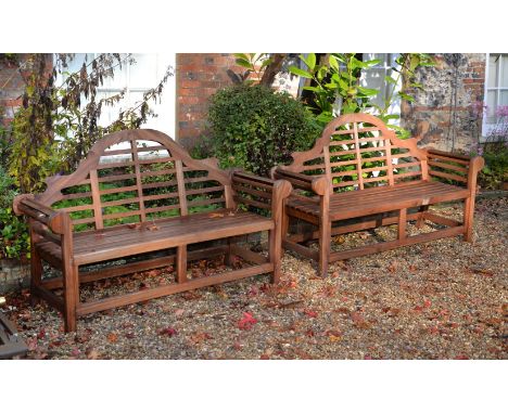 A pair of teak garden benches, of recent manufacture, in the manner of designs by Lutyens, the arched and serpentine backrest