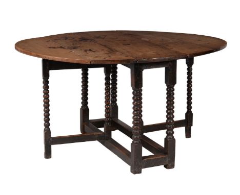 A William III oak gateleg table, circa 1695, the oval drop flaps above the bobbin supports and action, 80cm high, 153cm wide 