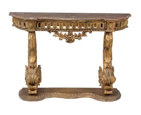 A giltwood and marble topped console table, late 19th century, of serpentine outline, with renaissance dolphin style supports