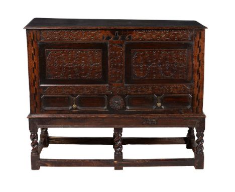 A carved oak mule chest, first quarter 18th century, bearing date 1716 to the frieze, on an associated stand, with barleytwis