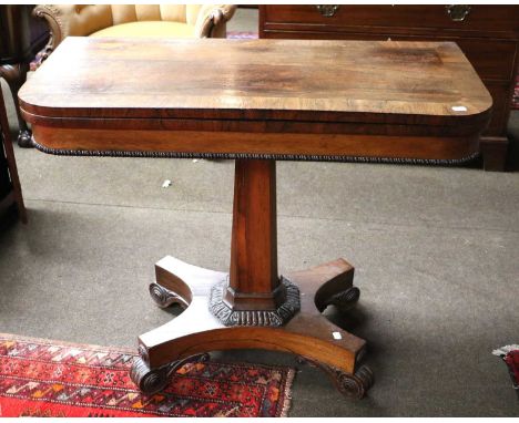 A William IV Rosewood Fold Over Card Table, crossbanded, on canted square section supports, with a shaped plinth over carved 