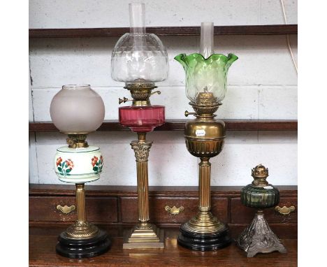 A Victorian Brass Based Oil Lamp, with cranberry font, on corinthian column; together with three similar oil lamps (4)Cranber
