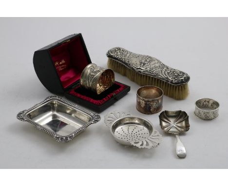 A MIXED LOT:- A late Victorian chased napkin ring, initialled (cased), two other napkin rings, also initialled, a small recta
