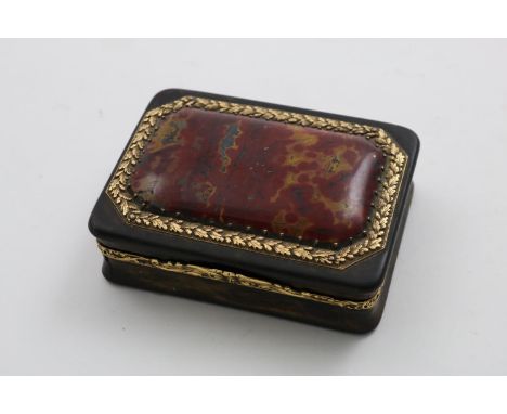 A GEORGE III GOLD MOUNTED TORTOISESHELL SNUFF BOX rectangular with chased borders, the cover set with a canted panel of red &
