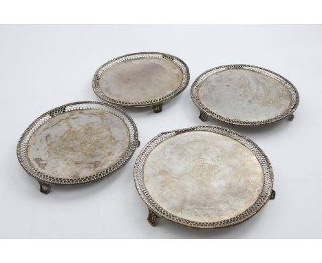 TWO MATCHING PAIRS OF GEORGE III CIRCULAR SALVERS with pierced and beaded borders and feet; one pair with an engraved coat of