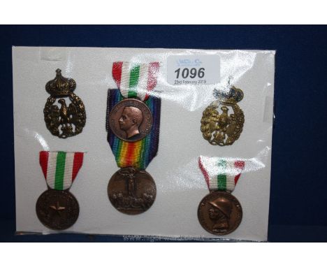 A small board of four Italian military medals, two vintage cap Badges and five wartime bank notes; apart from the WWI Victory