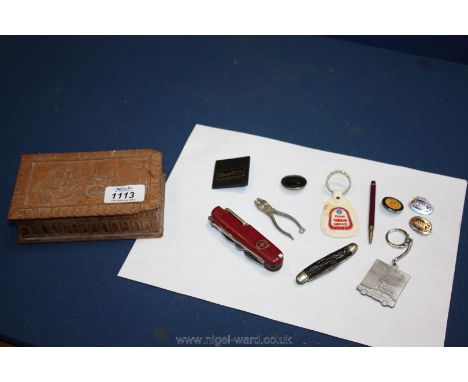 A small wooden box with miscellaneous penknives, enamel badges, etc.