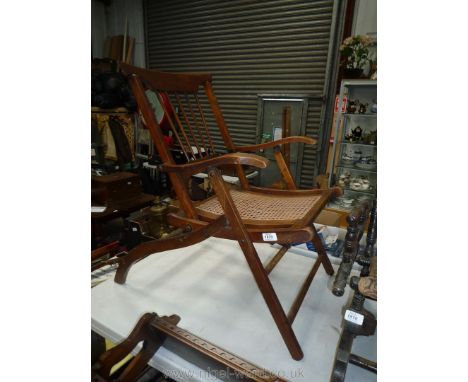 An unusual Mahogany framed folding Elbow Chair having a stick back and caned seat