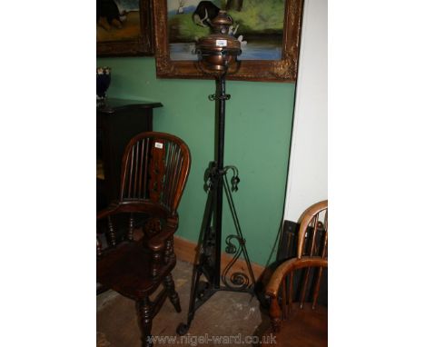 A floor standing oil lamp on a wrought iron base.
